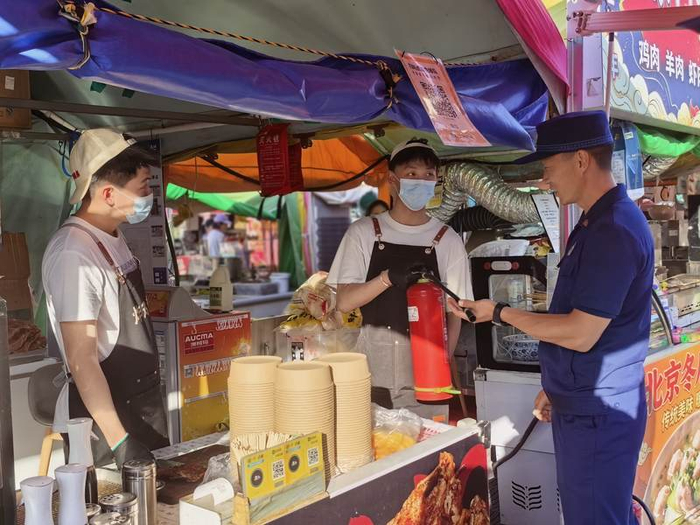消防救援人员穿梭于熙攘的摊位间，对用火、用电、消防设施等关键环节展开“地毯式”排查。通州消防供图