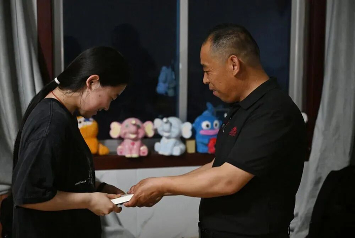5月18日，在河南商丘永城市的家中，苏小锋给三女儿送书，鼓励她多读书。