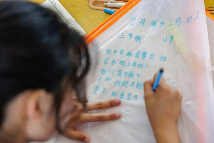 ▲5月13日，乡土教室里，女孩将自己最喜欢的一首诗写在风筝上。新京报记者 王子诚 摄
