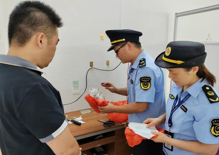 执法人员检查经营者自制的膏药及其原料。灵山县市场监管局供图
