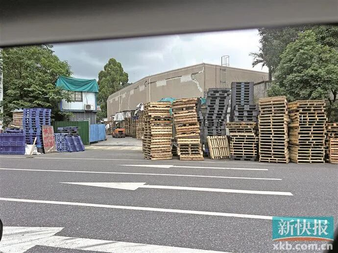 ■在护林路三期路段上，有厂房门前道路上堆放了大量货物及尾板。