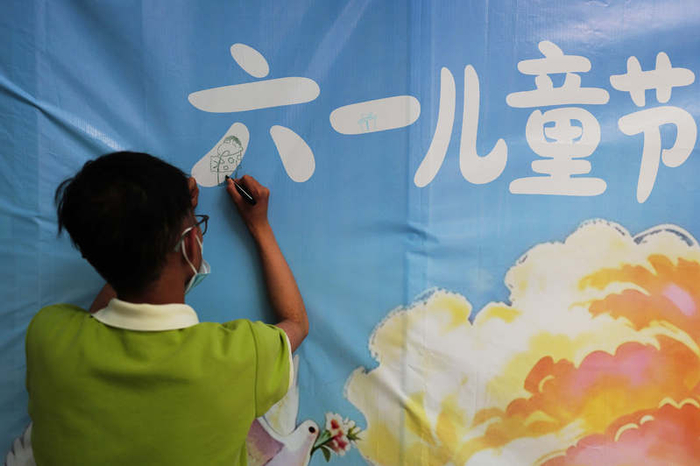 活动开始前，一个参与演出的小朋友在签到板上签到。新京报记者 郭延冰 摄