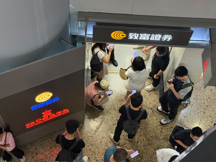 西九龙高铁站出口的致富门店，内地投资者围在门店口进行线上开户申请。图片来源：每经记者 黄婉银摄