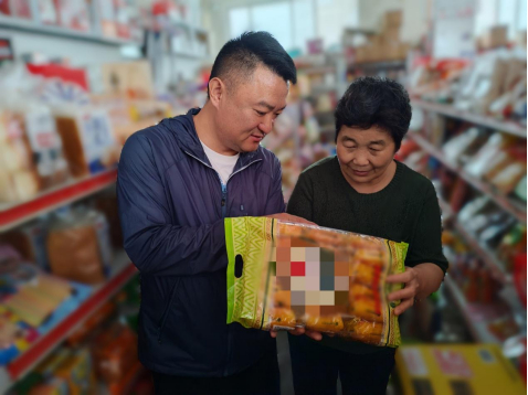 图为工作人员帮助老年零售户梳理库存，排查临期商品（泰安烟草供图）
