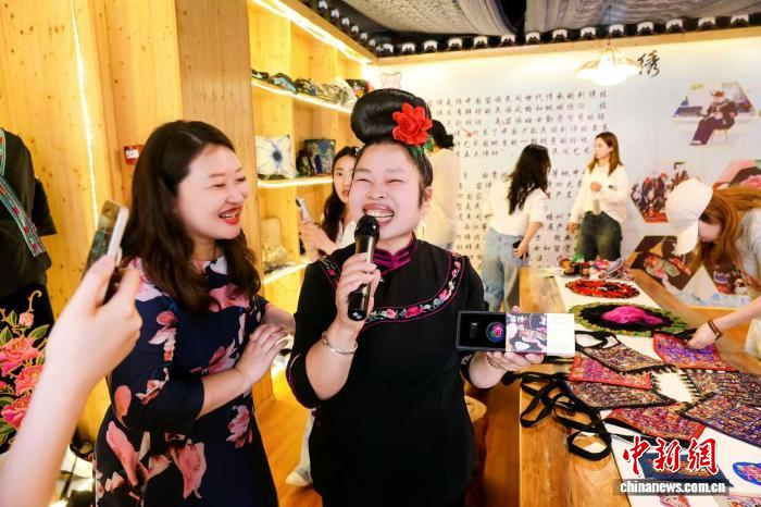 图为侯昌菊展示绣娘制作的苗绣系列产品。吴勇 摄