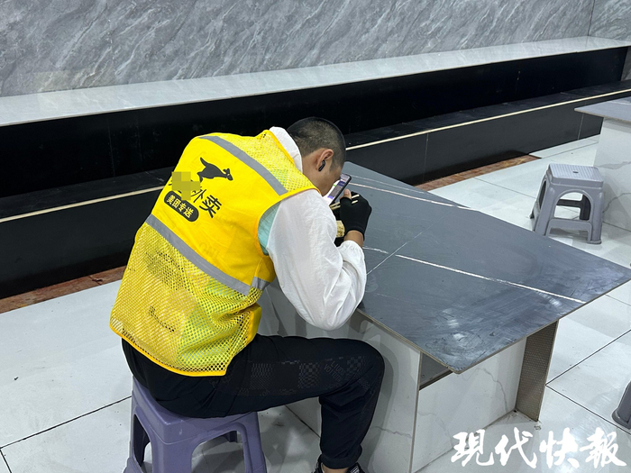 外卖小哥在店内吃面