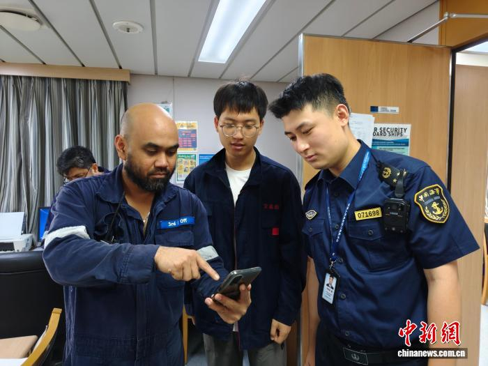 海事执法人员向国际海员普及使用“船员畅行”微信小程序。赵刚摄