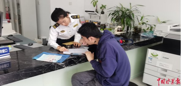 海事人员为小Z收办证材料。