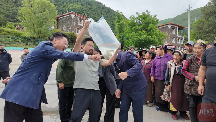 马尔康活动现场，大家围观即将被放流的鱼苗。