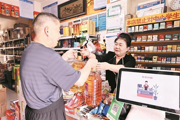 6月1日，市民（左）在六师五家渠市永久粮油商店采购粮油。 兵团日报常驻记者 李华北 摄