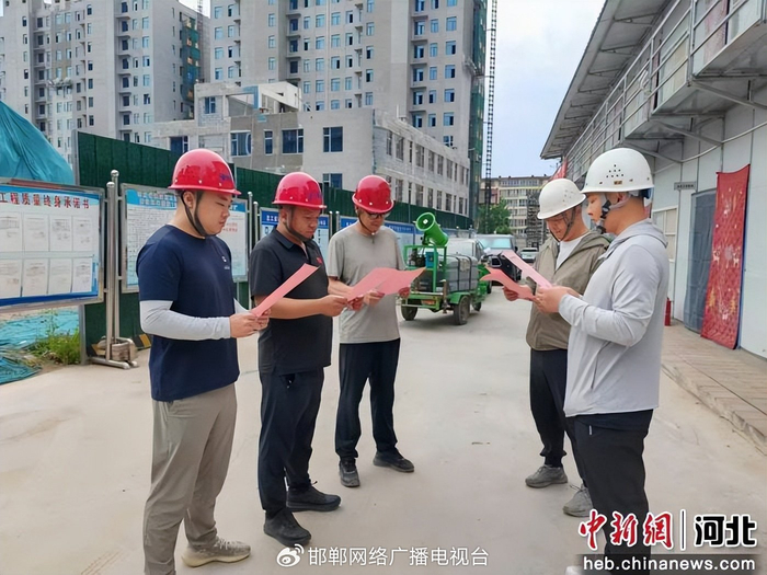 图为工作人员深入工地宣讲政策停工降噪护航高考。 张人鹏 摄