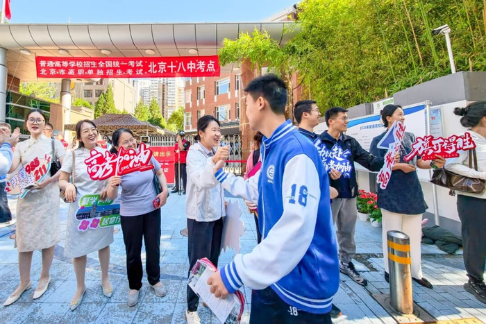 6月7日高考首日，在北京十八中考点，送考老师携带祝福语标牌来到考场门口列队欢送考生进入考场。  本报记者 邓伟摄