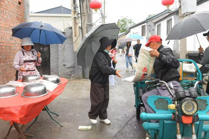 工作人员挨家挨户分发一次性餐具
