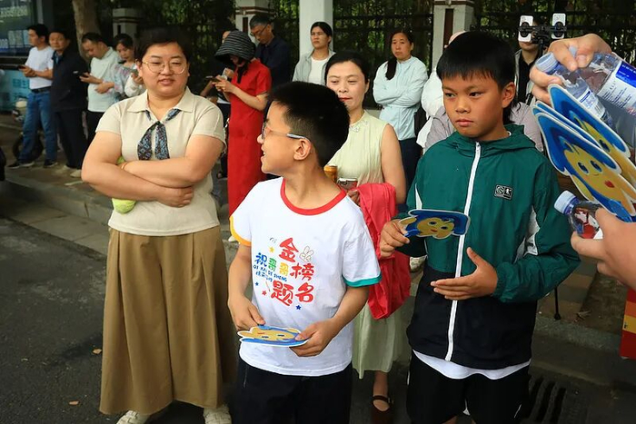 2026年6月7日，江苏淮安，高考首日，家长身着旗袍、手持向日葵在淮阴中学考点外送考。