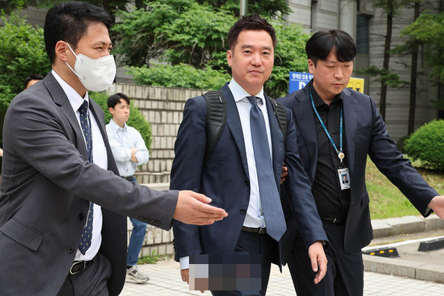 ▲ 5月26日上午，金世义（中）出席逮捕前嫌疑人讯问