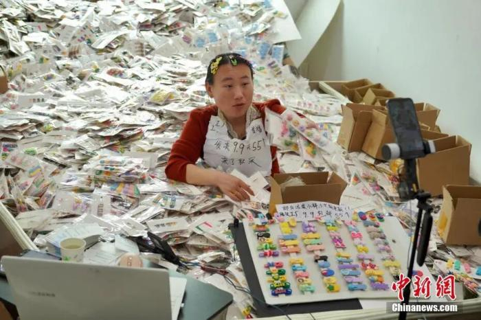 一名主播坐在发夹堆里，对着镜头讲解产品。董易鑫 摄