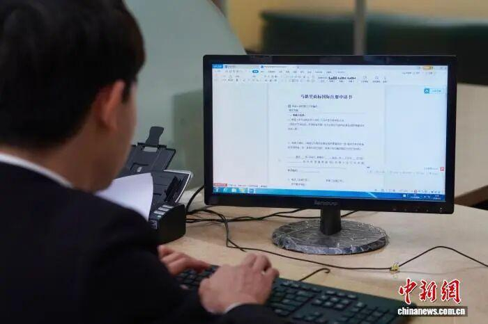 商户填写马德里商标国际注册申请书。董易鑫 摄