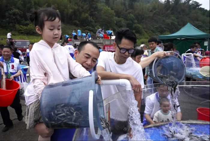 ▲ 刘梓雅和爸爸一起参与长江鲟放流。