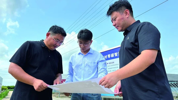 李瑶（左）在“智慧乡村项目”现场看图纸