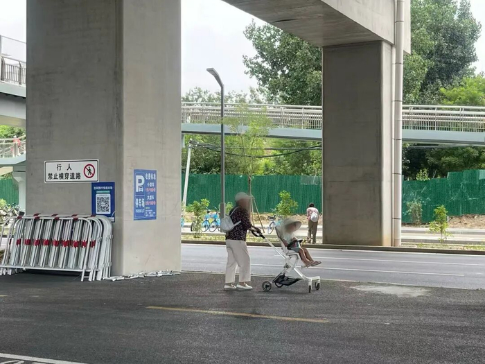 京密路1号停车场，记者探访时部分隔离护栏被拆除，有工人在改建花池，有老人推着孩子在桥下穿行。