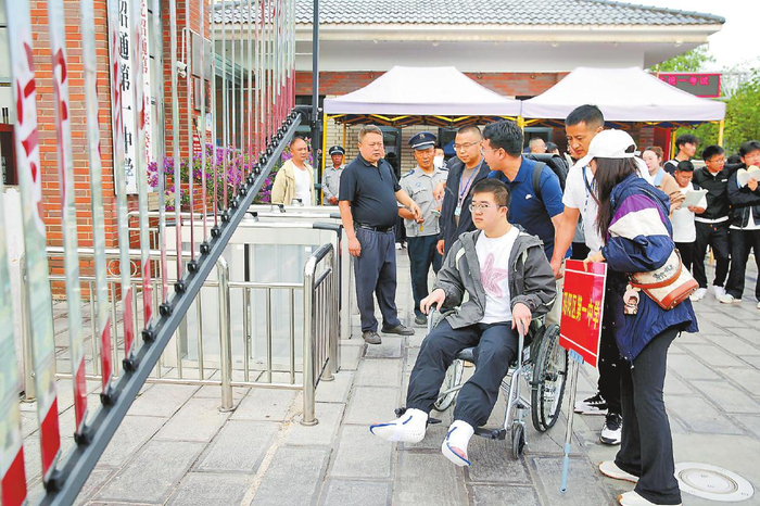 　　图③：6月7日，在昭通市第一中学，一名腿部受伤的考生在老师护送下准备进入考场。　　新华社发　张广玉　摄