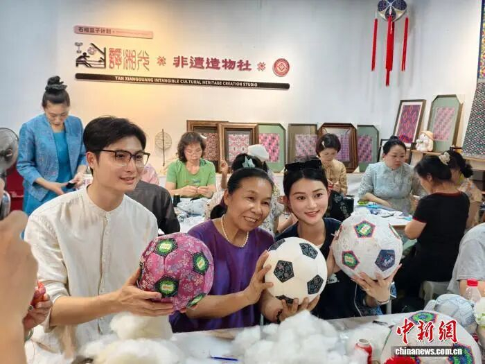 图为谭湘光展示其制作的壮锦足球。受访者 供图