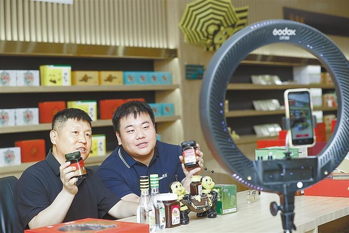     廊坊百花蜂产品有限公司蜜蜂文化体验馆内，工作人员通过网络直播向网友介绍产品。本报记者 陈童 摄