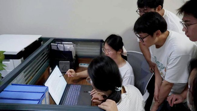 图为团队成员在办公室讨论实验方案