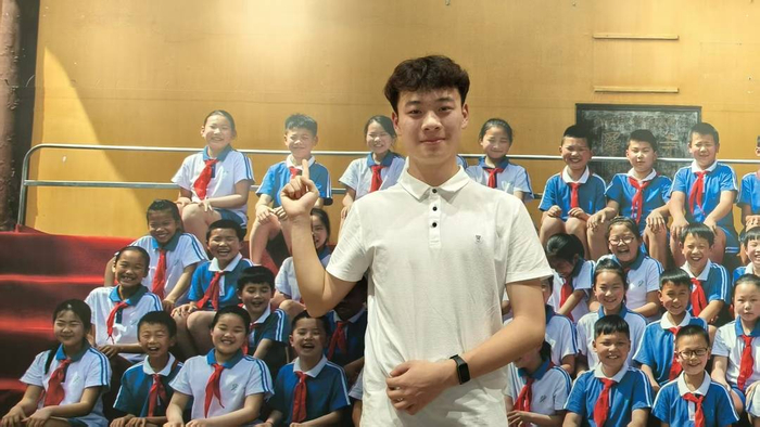 廖铖俊在合影中找到了自己（伍勇 摄）