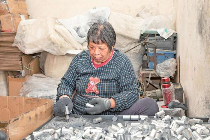 任金凤在家中分拣打磨从工厂带回的零件，计件获酬补贴家用。 江阴市委宣传部供图