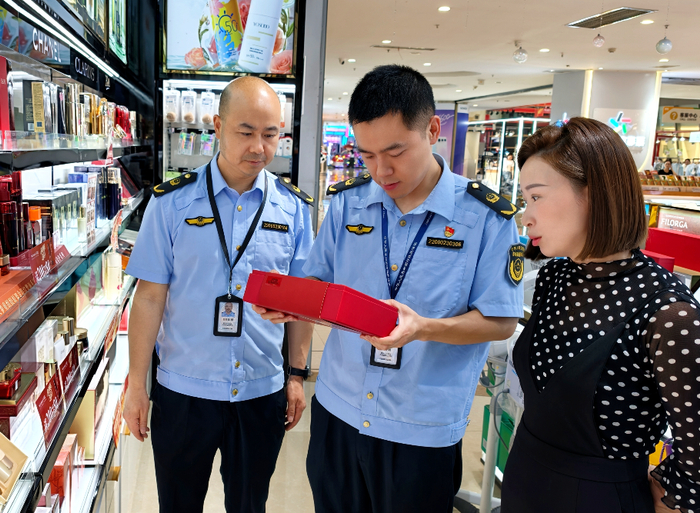 6月11日，执法人员在一家超市通过核查化妆品标识检查化妆品质量。