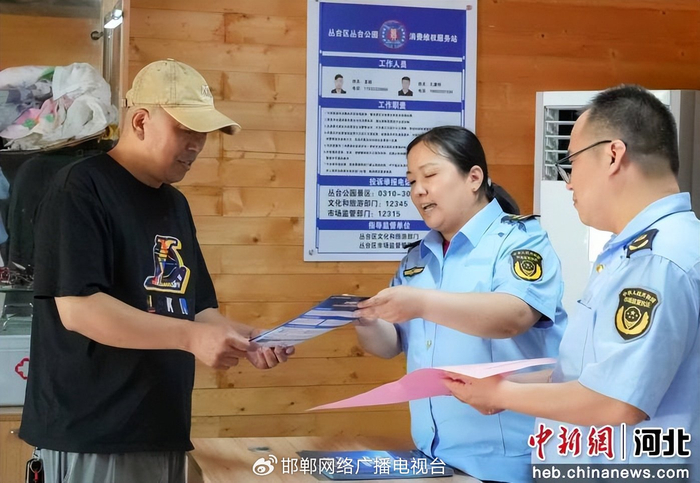 图为工作人员向游客讲解消费维权服务站功能并普及相关知识。 王倩倩 摄