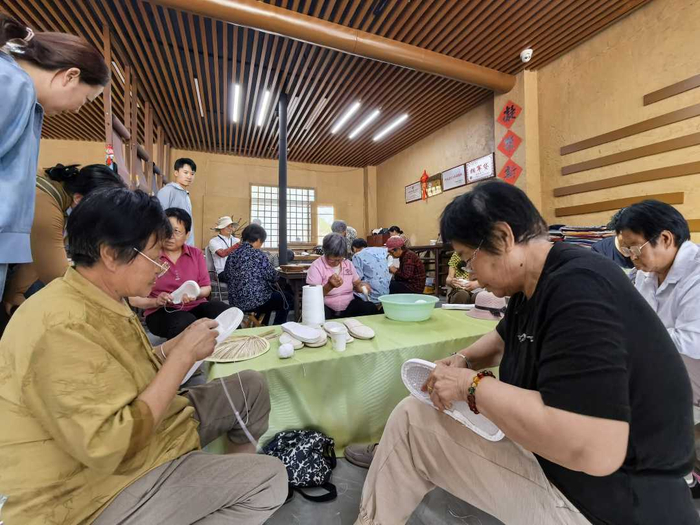 村民在助农惠农展销基地里边聊天边作工。资料图片