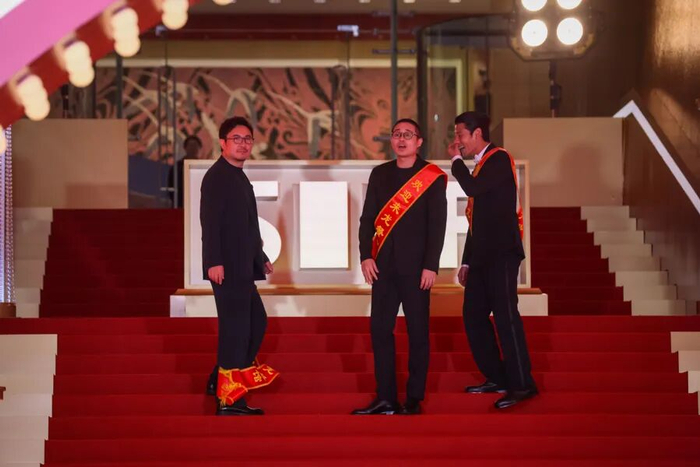 图为：《欢迎来到龙餐馆》剧组，沈腾偶然落下了身上的条幅，让人忍俊不禁。