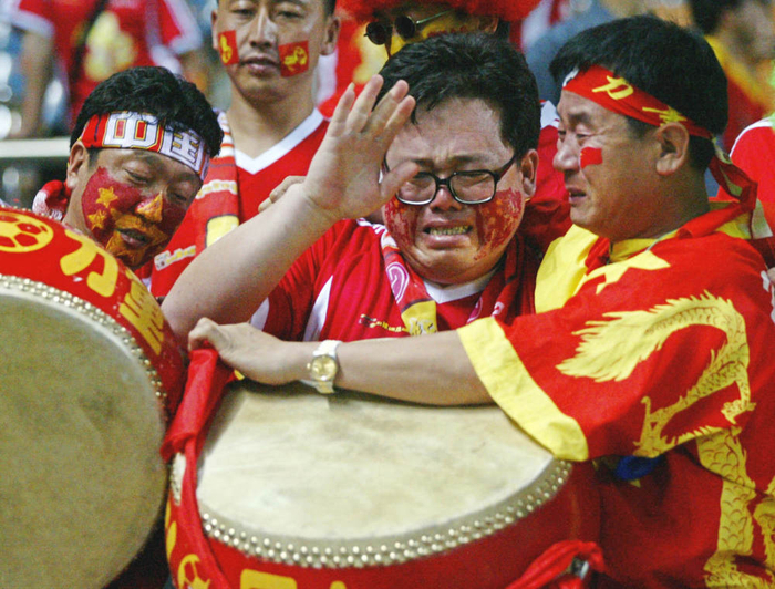图为2002年6月8日，在韩日世界杯C组第二轮中国队以0:4败于巴西队的比赛后，中国球迷在看台上痛哭流涕。新华社/法新