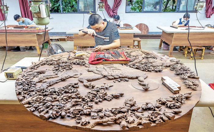 图为三福古典家具生产车间内，工艺师在精心创作。　全媒体记者 蔡昊 摄