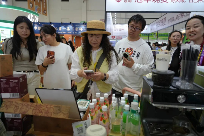 市民游客在第10届南博会上购买品尝老窝火腿拿铁。泸水市融媒体中心 供图