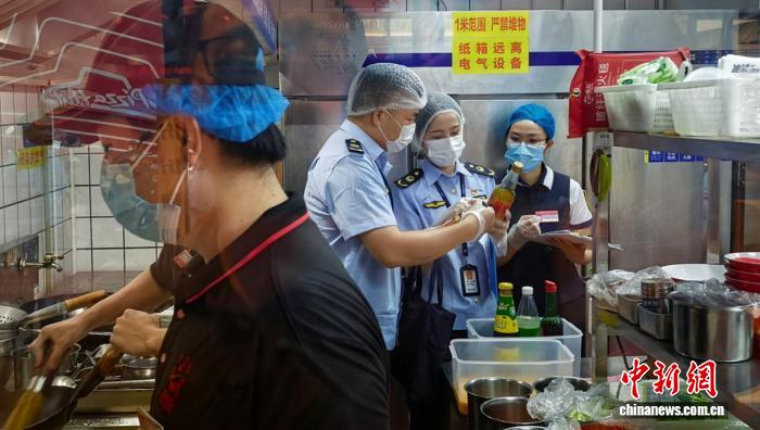 图为广西市场监管部门执法员对网络餐饮店后厨进行检查。林浩 摄