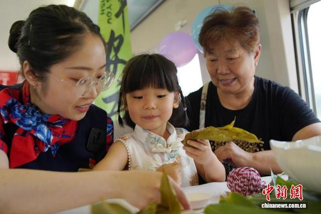 图为乘务员指导小旅客包粽子。米思齐 摄 