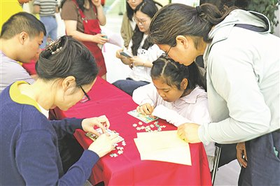 在贵阳国际人才城，群众踊跃参与拼图赢“粮票”活动。  陈佳艺 摄