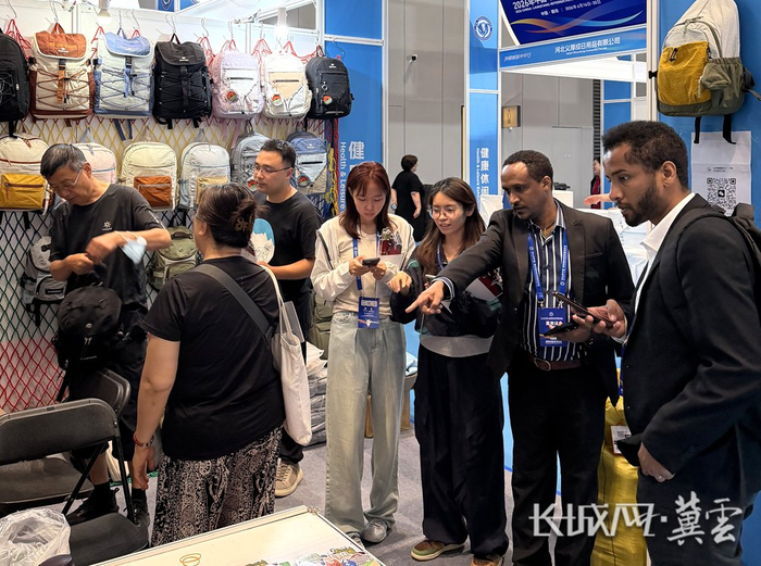 来自塞尔维亚的客商在河北丹诺森箱包制造有限公司展区选品。谭海燕 摄