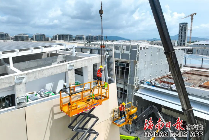 6月19日，位于三亚市海棠湾的三亚国际免税城三期项目施工现场，工人们在忙着安装幕墙。 王程龙 摄
