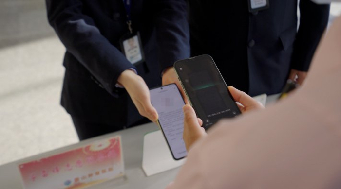 执法人员“亮码入企”，企业工作人员扫码核验。眉山市司法局供图