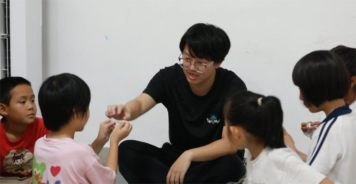 课后杨宏宇和孩子们在“护苗学堂”进行游戏互动。王恩慧/摄