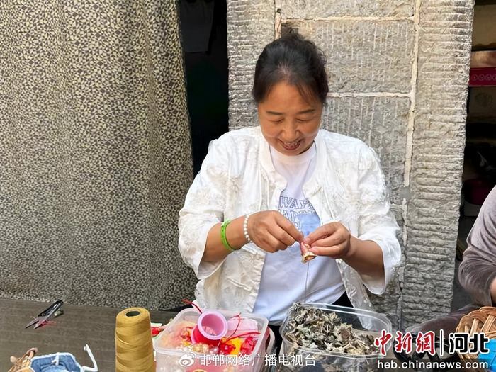 图为村民正亲手缝制端午香包。 赵丹丹 摄
