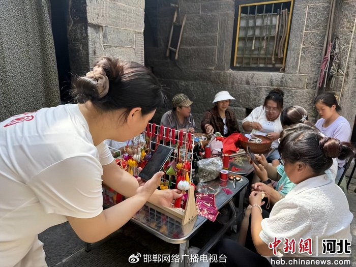 图为村民现场直播卖手作香包与彩绳。 赵丹丹 摄