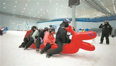 　　右图：市民游客划雪地龙舟。