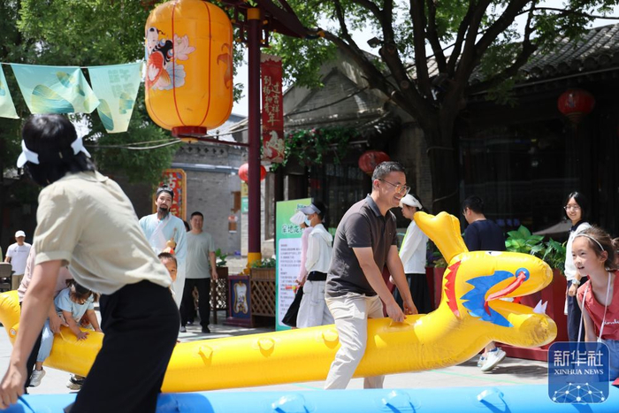 ↑ 6月21日，游客在天津市西青区杨柳青古镇体验旱地龙舟。新华社记者 李然 摄