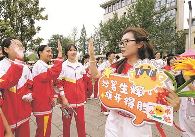 6月20日上午，在北京师范大学贵安新区附属学校考点外，老师和即将进入考场的考生击掌。                          贵阳日报融媒体记者 石照昌 摄