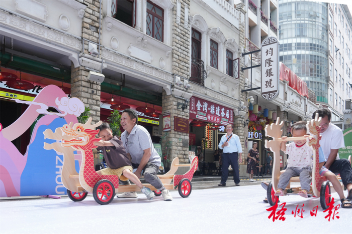 6月19日，市民在骑楼城玩旱地划龙舟游戏，欢度端午佳节。杨扬 摄